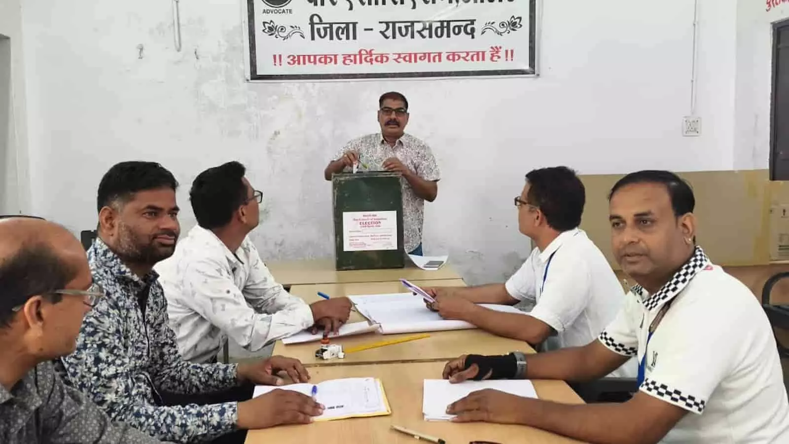 आमेट न्यायालय परिसर में बार काउंसिल चुनाव के दौरान मतपेटी में वोट डालता व्यक्ति और बैठे हुए अधिवक्ता। आमेट न्यायालय परिसर में बार काउंसिल चुनाव के दौरान मतपेटी में वोट डालता व्यक्ति और बैठे हुए अधिवक्ता।
