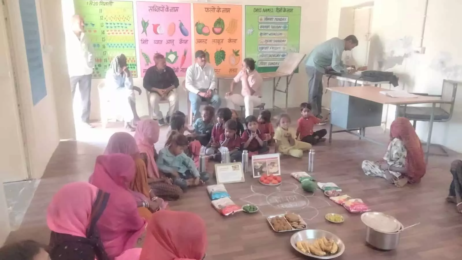लसाडिया के नन्दघर आंगनबाड़ी केंद्र में पोषण पखवाड़ा के दौरान जमीन पर बैठे बच्चे और महिलाएं। लसाडिया के नन्दघर आंगनबाड़ी केंद्र में पोषण पखवाड़ा के दौरान जमीन पर बैठे बच्चे और महिलाएं।