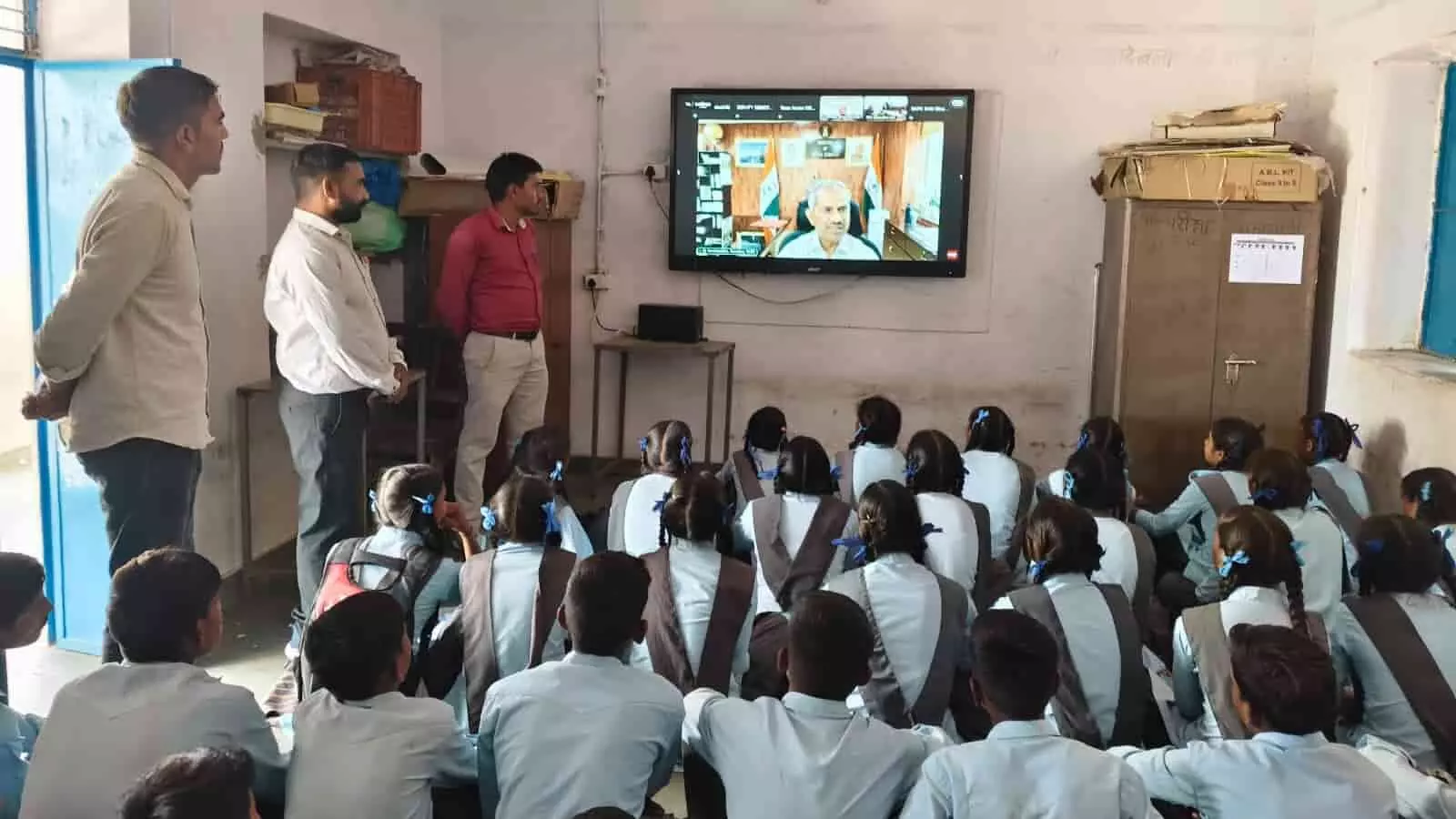 डिजिटल स्क्रीन पर पर्यावरण फिल्म देखते स्कूली बच्चे और शिक्षक लसाडिया के सरकारी स्कूल में पृथ्वी दिवस पर।