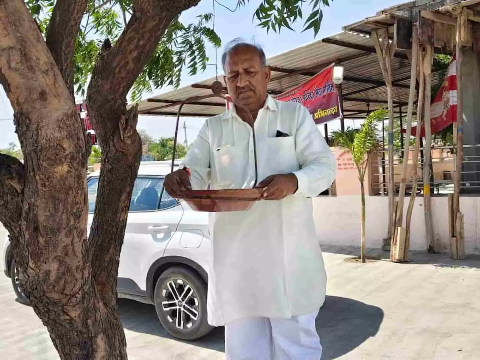 निम्बाहेड़ा में पेड़ पर पक्षियों के लिए पानी का परिंडा बांधते हुए एक व्यक्ति। निम्बाहेड़ा में पेड़ पर पक्षियों के लिए पानी का परिंडा बांधते हुए एक व्यक्ति।