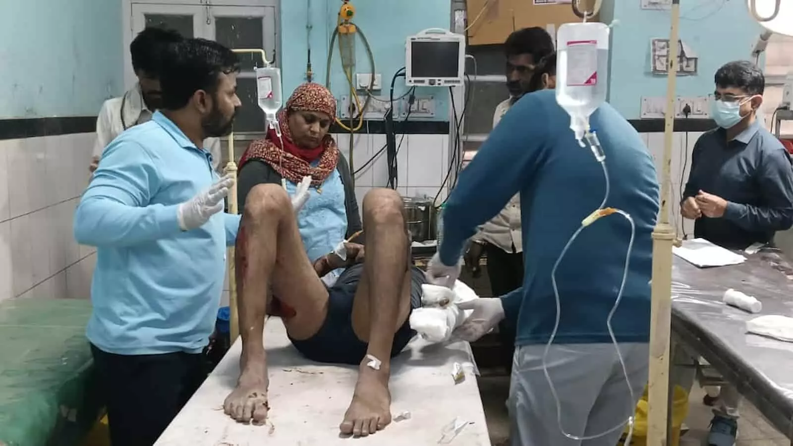 अस्पताल के स्ट्रेचर पर लेटा घायल व्यक्ति जिसका चिकित्सक और स्वास्थ्य कर्मी उपचार कर रहे हैं। अस्पताल के स्ट्रेचर पर लेटा घायल व्यक्ति जिसका चिकित्सक और स्वास्थ्य कर्मी उपचार कर रहे हैं।