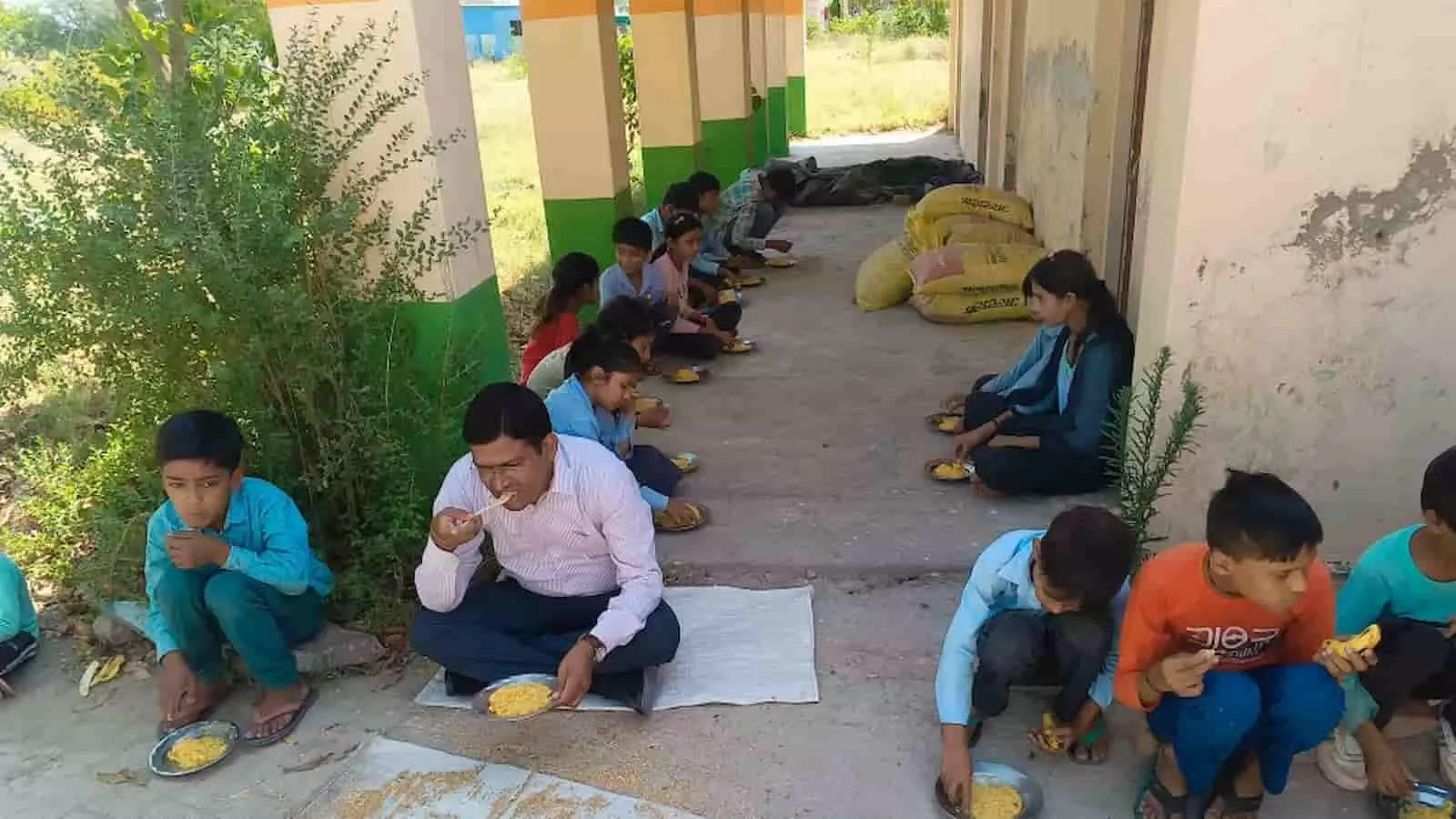 स्कूल के बरामदे में बच्चों के साथ बैठकर भोजन करते एसडीएम बृजेंद्र मीना और मिड-डे मील खाते विद्यार्थी। स्कूल के बरामदे में बच्चों के साथ बैठकर भोजन करते एसडीएम बृजेंद्र मीना और मिड-डे मील खाते विद्यार्थी।