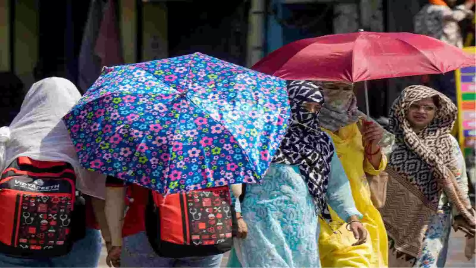 रंगीन छाता लिए हुए और चेहरे को कपड़े से ढंके हुए लोग सड़क पर गर्मी के दौरान। रंगीन छाता लिए हुए और चेहरे को कपड़े से ढंके हुए लोग सड़क पर गर्मी के दौरान।