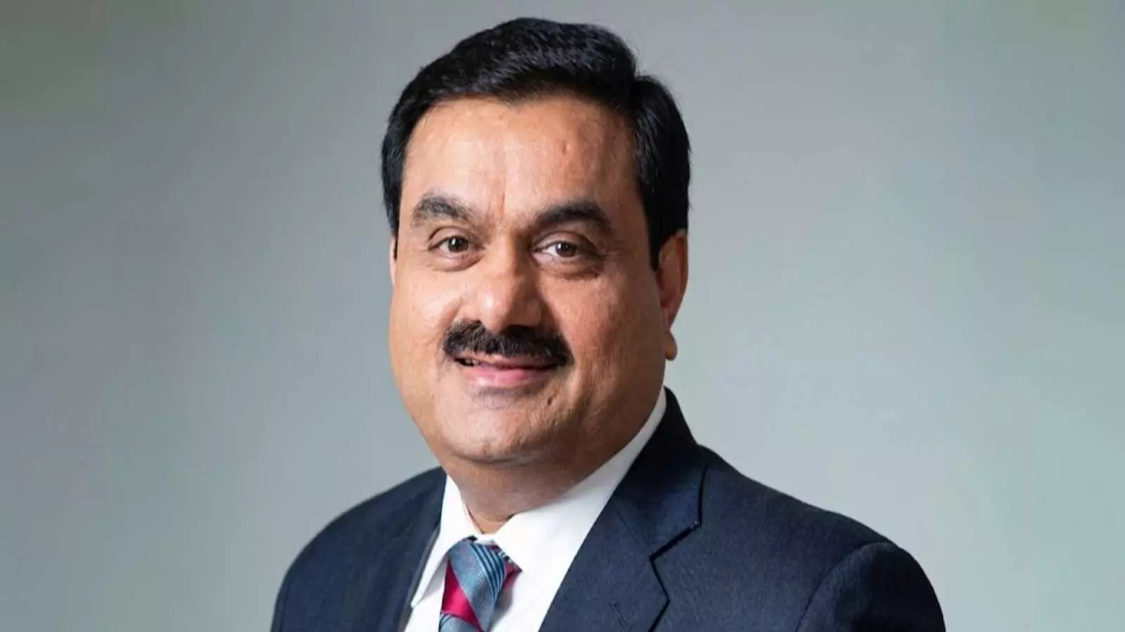 गहरे नीले सूट और लाल टाई में मुस्कुराते हुए गौतम अडानी की प्रोफाइल फोटो। गहरे नीले सूट और लाल टाई में मुस्कुराते हुए गौतम अडानी की प्रोफाइल फोटो।