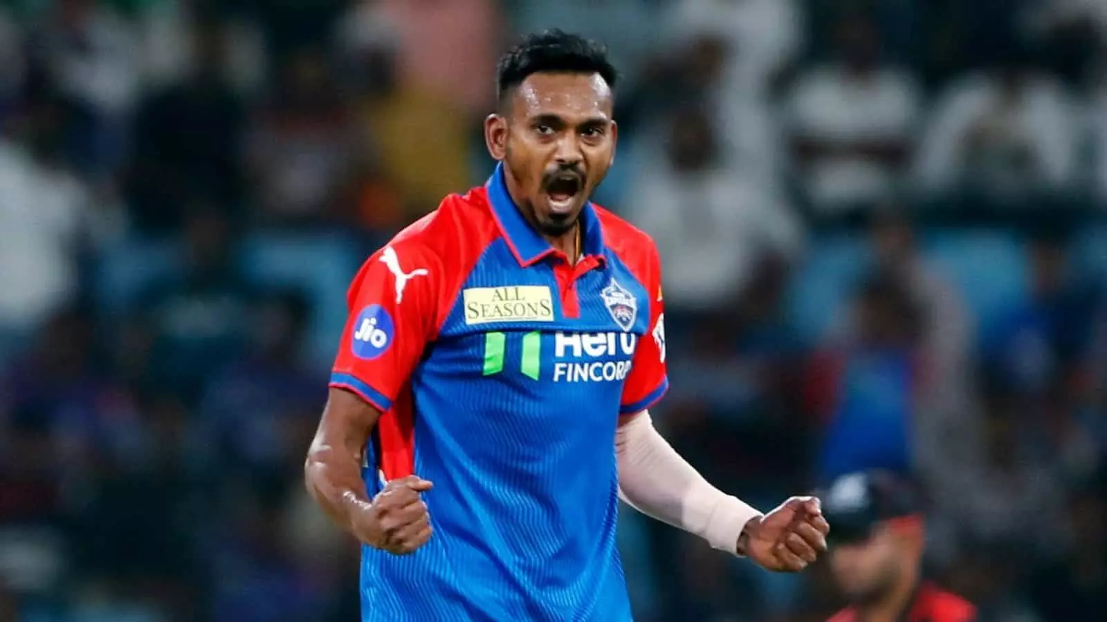 नीली और लाल जर्सी में श्रीलंकाई गेंदबाज दुश्मंथा चमीरा मैदान पर जोश में चिल्लाते हुए। नीली और लाल जर्सी में श्रीलंकाई गेंदबाज दुश्मंथा चमीरा मैदान पर जोश में चिल्लाते हुए।