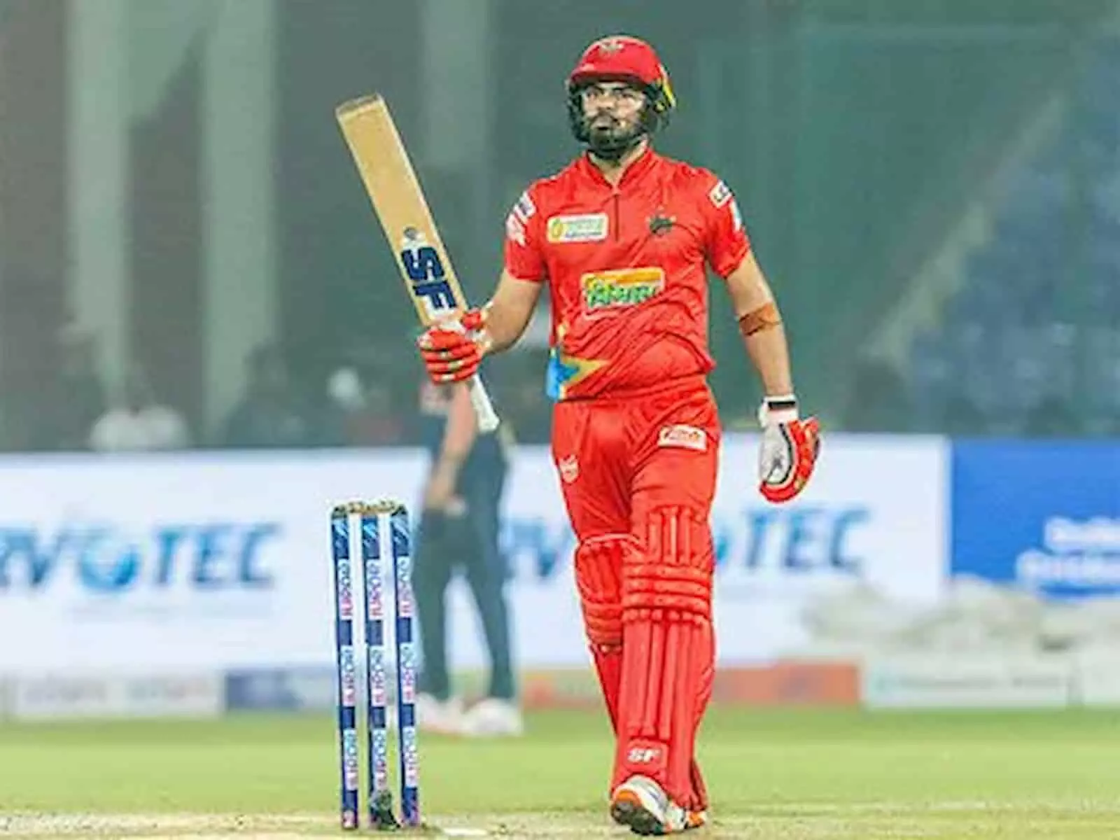 क्रिकेट मैदान पर लाल जर्सी और हेलमेट पहने बल्लेबाजी करते तेजस्वी सिंह दहिया। क्रिकेट मैदान पर लाल जर्सी और हेलमेट पहने बल्लेबाजी करते तेजस्वी सिंह दहिया।