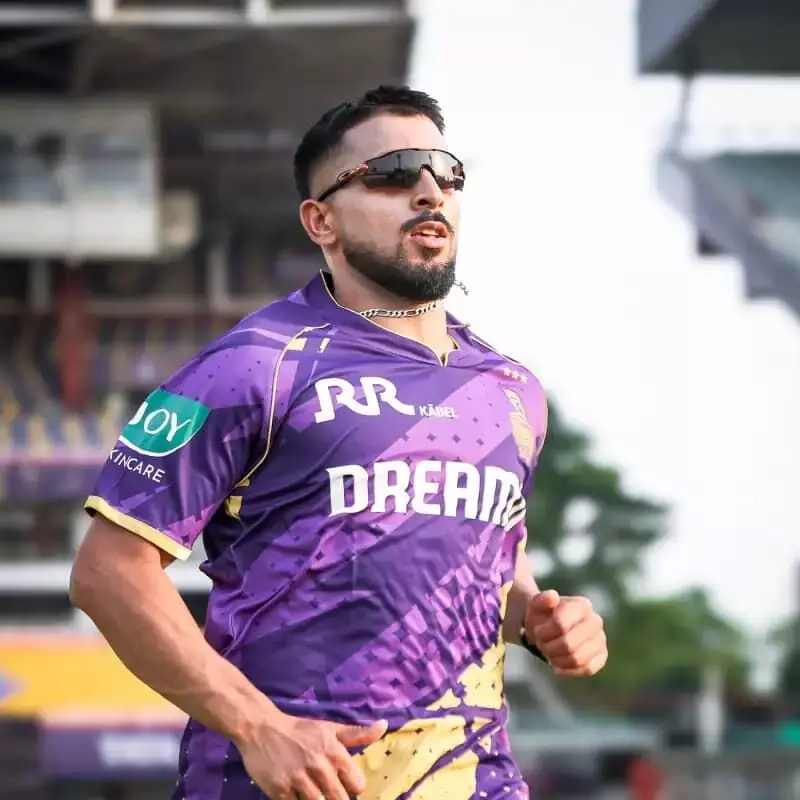 बैंगनी रंग की जर्सी और सनग्लासेस पहने उमरान मलिक क्रिकेट मैदान पर दौड़ते हुए। बैंगनी रंग की जर्सी और सनग्लासेस पहने उमरान मलिक क्रिकेट मैदान पर दौड़ते हुए।