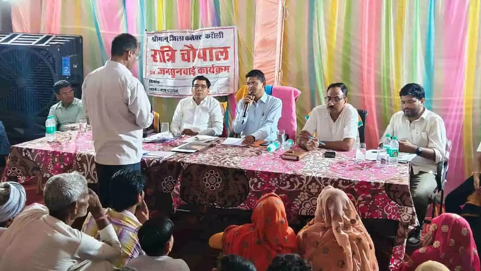 शहराकर ग्राम पंचायत में रात्रि चौपाल के दौरान मेज पर बैठे अधिकारी और सामने खडे ग्रामीण। शहराकर ग्राम पंचायत में रात्रि चौपाल के दौरान मेज पर बैठे अधिकारी और सामने खडे ग्रामीण।