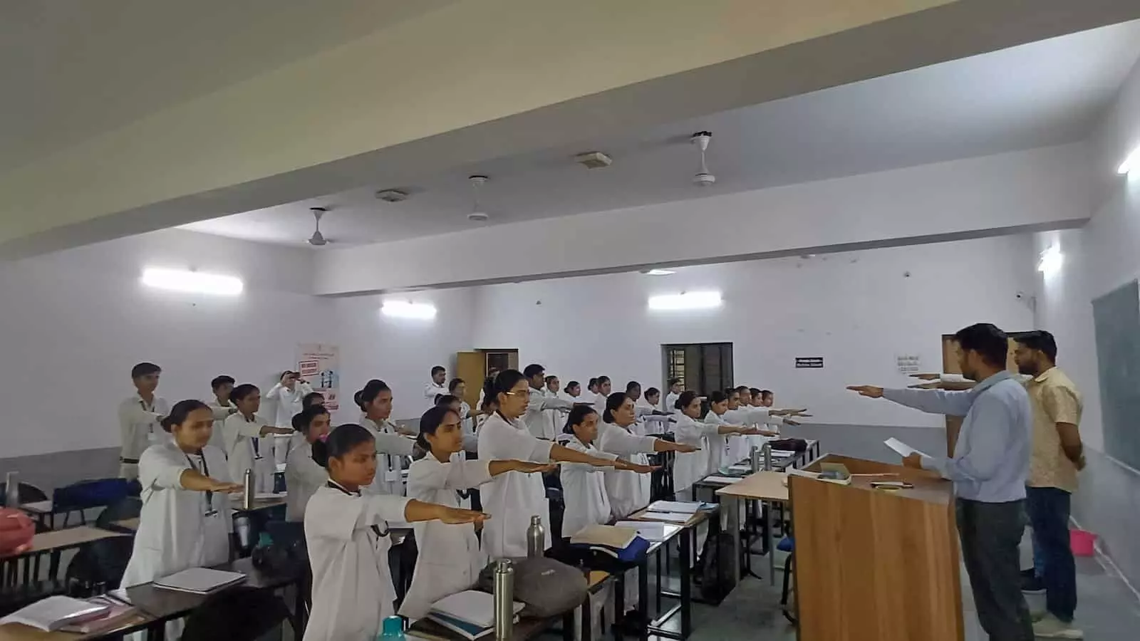 स्वास्थ्य केंद्र में हाथ आगे कर मलेरिया उन्मूलन की शपथ लेते सफेद कोट पहने चिकित्सा छात्र। स्वास्थ्य केंद्र में हाथ आगे कर मलेरिया उन्मूलन की शपथ लेते सफेद कोट पहने चिकित्सा छात्र।