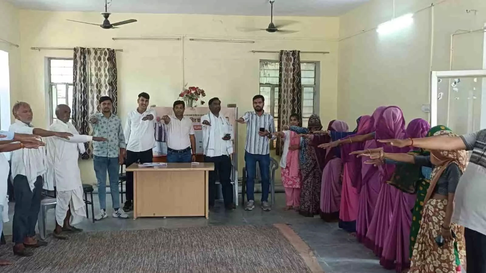 सवाई माधोपुर में ग्राम सभा के दौरान हाथ बढ़ाकर निक्षय शपथ लेते हुए पुरुष और महिलाएं। सवाई माधोपुर में ग्राम सभा के दौरान हाथ बढ़ाकर निक्षय शपथ लेते हुए पुरुष और महिलाएं।