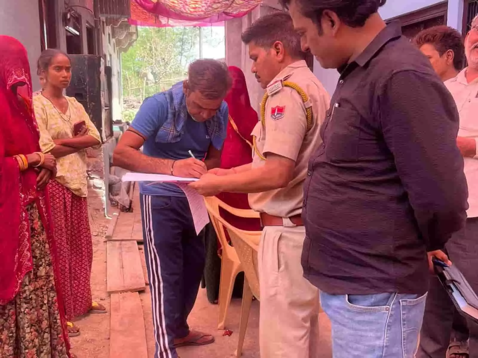 फतहनगर के चगेड़ी गांव में पुलिस अधिकारी के सामने दस्तावेज पर हस्ताक्षर करते हुए ग्रामीण पुरुष। फतहनगर के चगेड़ी गांव में पुलिस अधिकारी के सामने दस्तावेज पर हस्ताक्षर करते हुए ग्रामीण पुरुष।