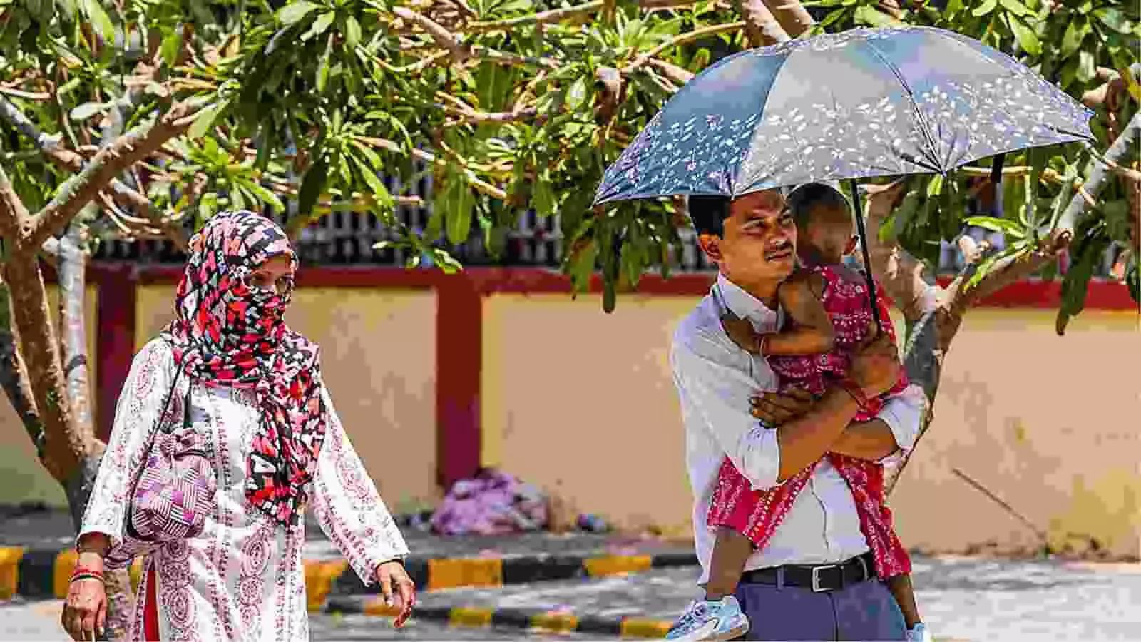 दिल्ली की सड़क पर धूप से बचने के लिए छतरी और स्कार्फ का उपयोग करते लोग। दिल्ली की सड़क पर धूप से बचने के लिए छतरी और स्कार्फ का उपयोग करते लोग।