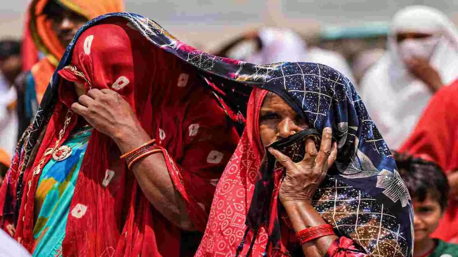 दिल्ली की गर्मी में महिलाएं अपने सिर और चेहरे को रंगीन दुपट्टे से ढके हुए बाहर चल रही हैं।