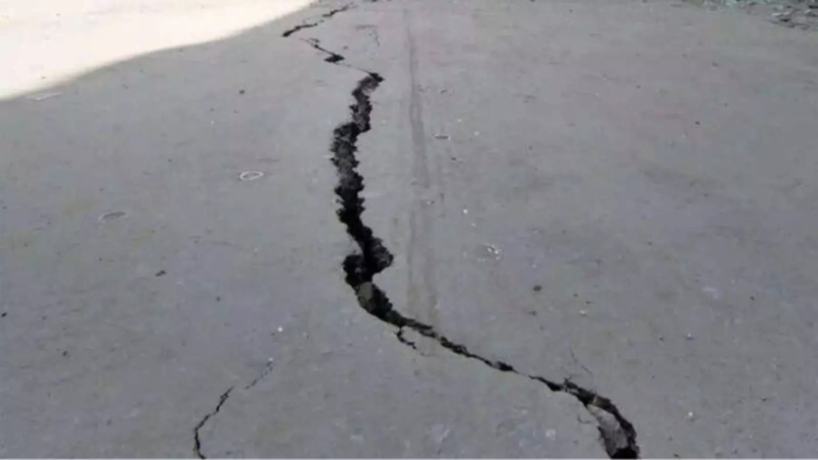 डामर की सड़क पर लंबी और गहरी दरार भूकंप के झटकों के बाद होक्काइडो में दिख रही है।