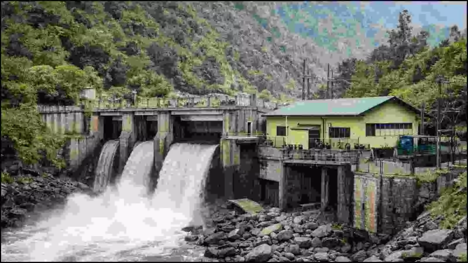 पहाड़ों के बीच बहते पानी के ऊपर बना एक छोटा कंक्रीट का बांध और पीली इमारत वाला बिजली घर।