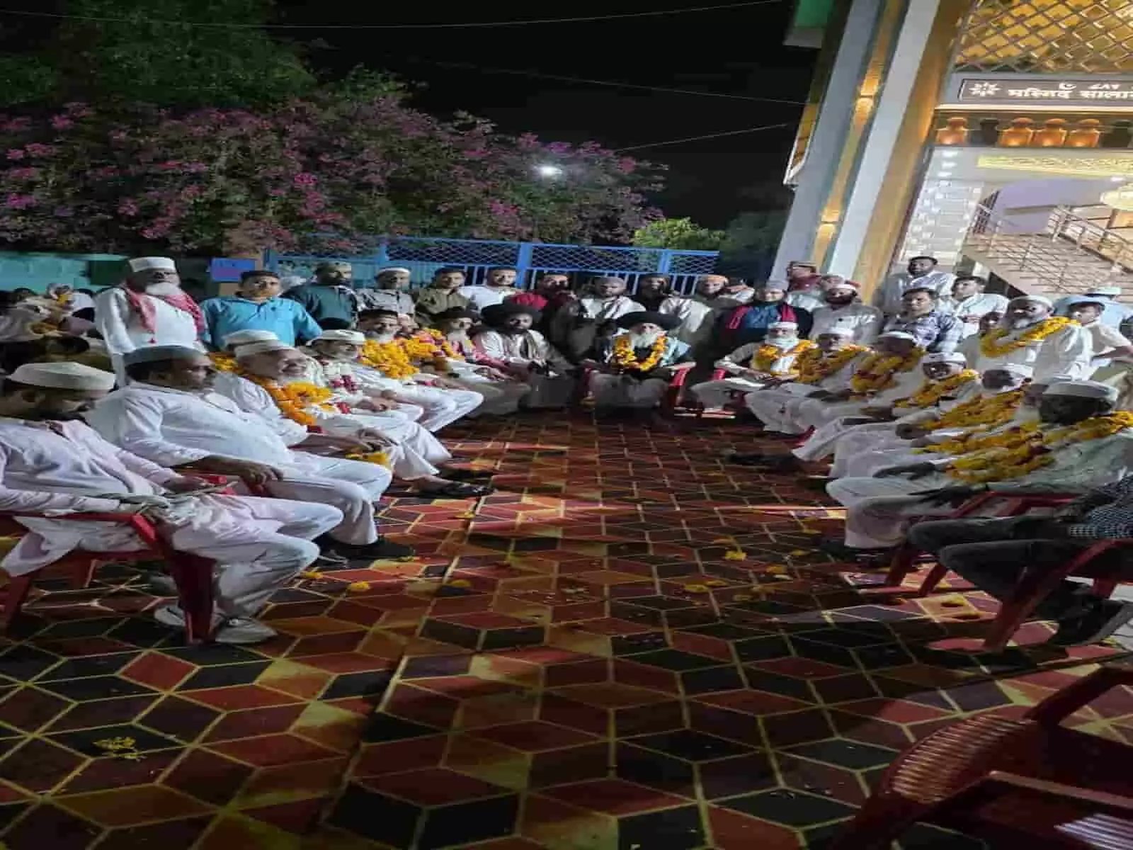 शाही मस्जिद के बाहर कुर्सियों पर बैठे फूल-माला पहने हज यात्री और खड़े कमेटी सदस्य। शाही मस्जिद के बाहर कुर्सियों पर बैठे फूल-माला पहने हज यात्री और खड़े कमेटी सदस्य।