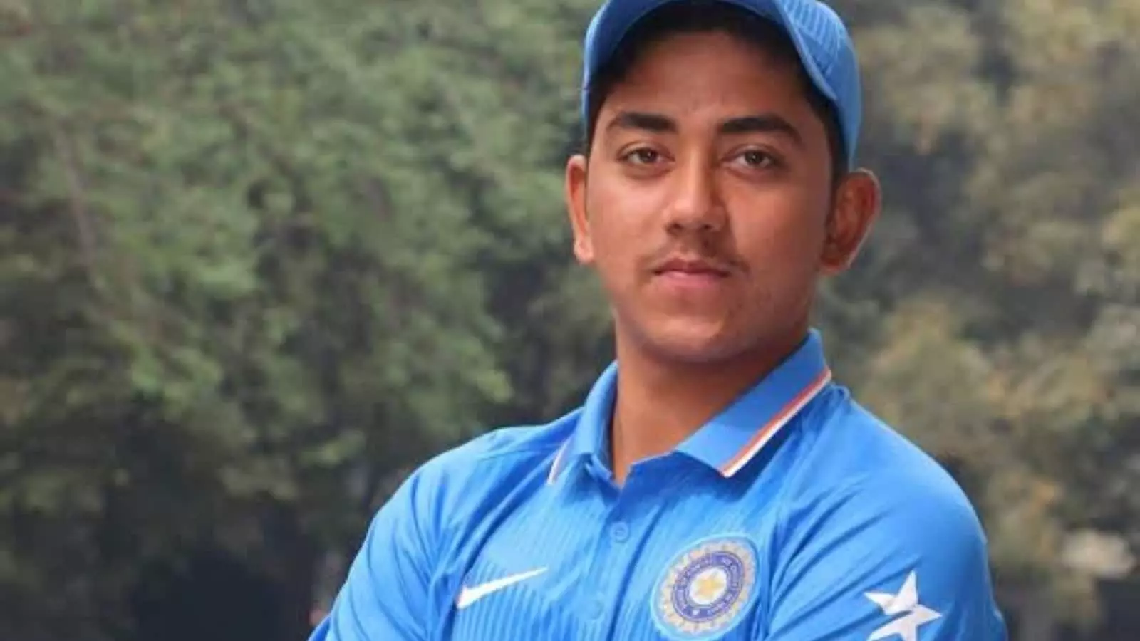 नीली क्रिकेट जर्सी और टोपी पहने हुए युवा क्रिकेटर मयंक रावत की मैदान पर खींची गई एक तस्वीर।