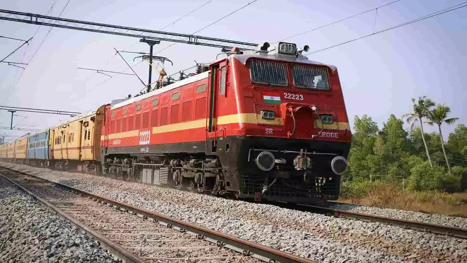 रेल की पटरी पर चलती हुई लाल रंग के इंजन वाली भारतीय रेलवे की यात्री ट्रेन। रेल की पटरी पर चलती हुई लाल रंग के इंजन वाली भारतीय रेलवे की यात्री ट्रेन।
