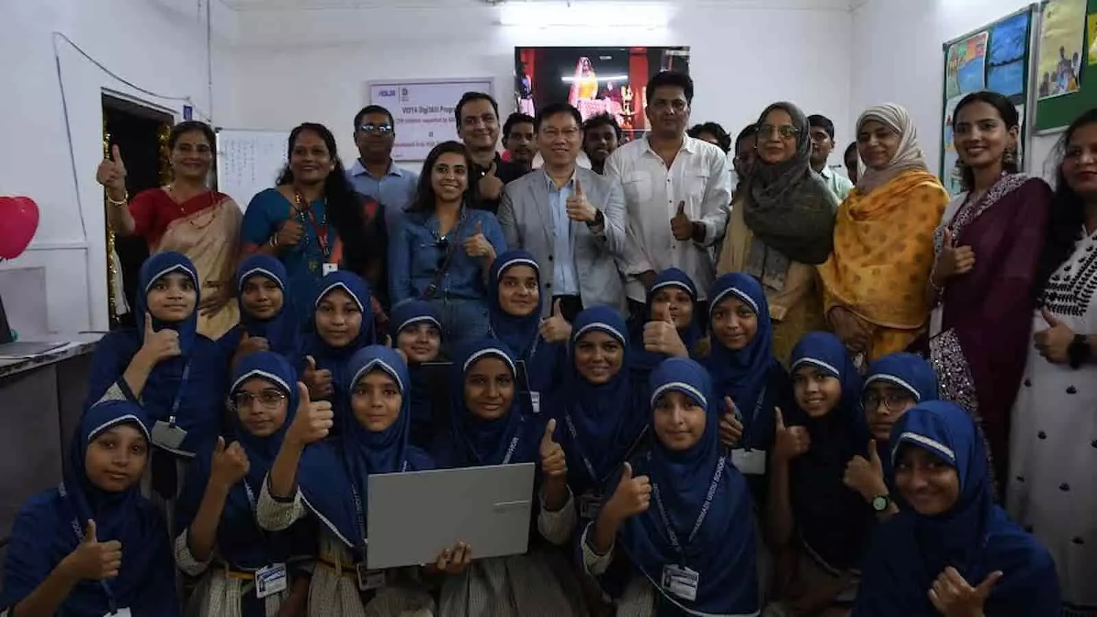 स्कूल क्लासरूम में नीले हिजाब पहने छात्राएं और एसुस प्रतिनिधि लैपटॉप के साथ ग्रुप फोटो खिंचवाते हुए। स्कूल क्लासरूम में नीले हिजाब पहने छात्राएं और एसुस प्रतिनिधि लैपटॉप के साथ ग्रुप फोटो खिंचवाते हुए।