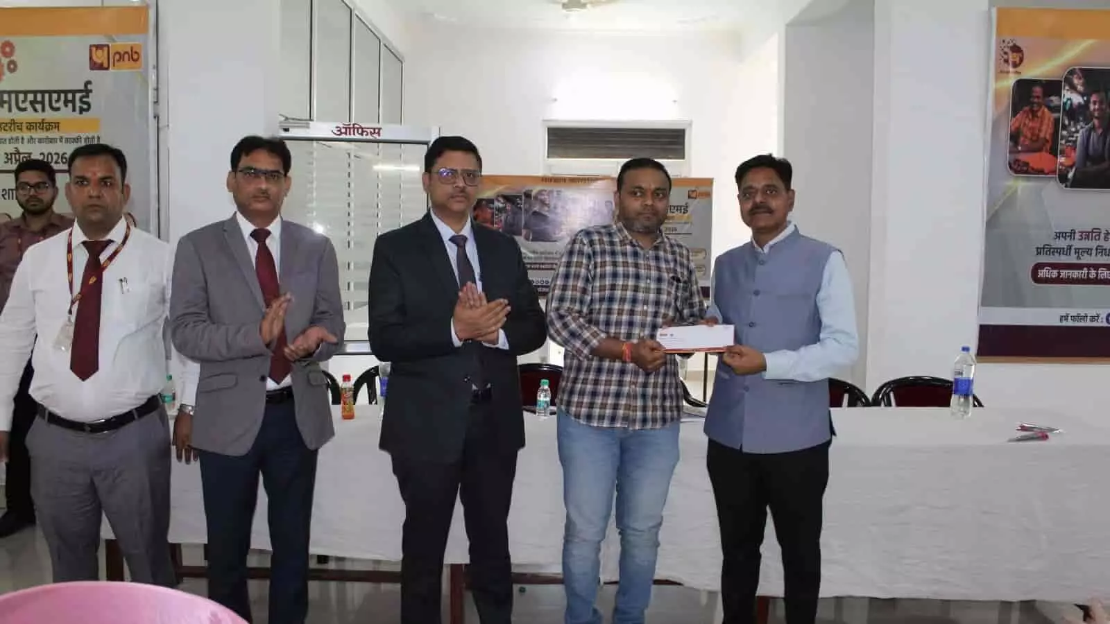 पीएनबी बैंक अधिकारी बीआइए शाखा में एमएसएमई आउटरीच कार्यक्रम के दौरान ग्राहक को दस्तावेज सौंपते हुए।