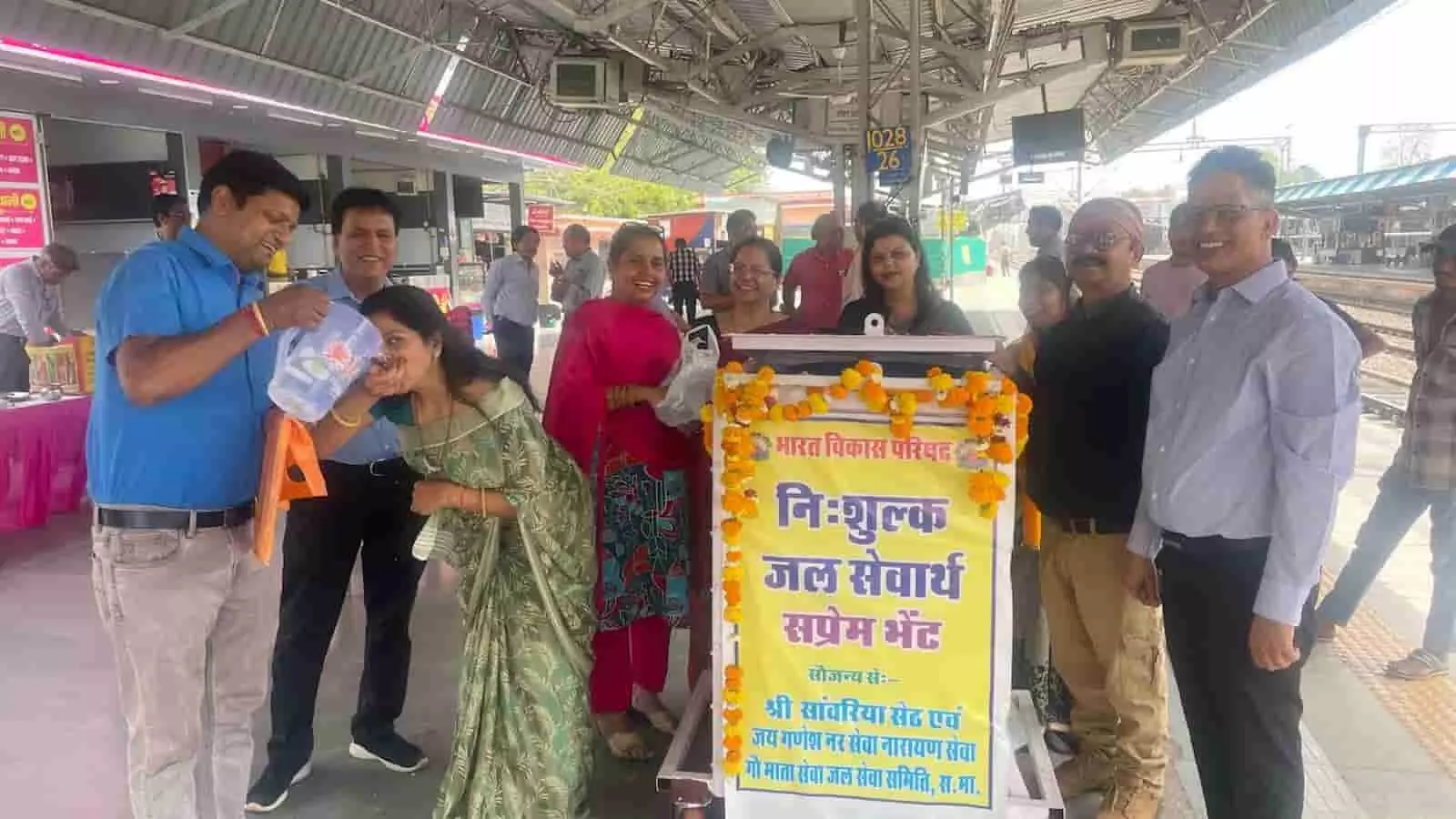 सवाई माधोपुर रेलवे स्टेशन के प्लेटफार्म पर भारत विकास परिषद के सदस्य जल सेवा प्रकल्प का पोस्टर पकड़े हुए।
