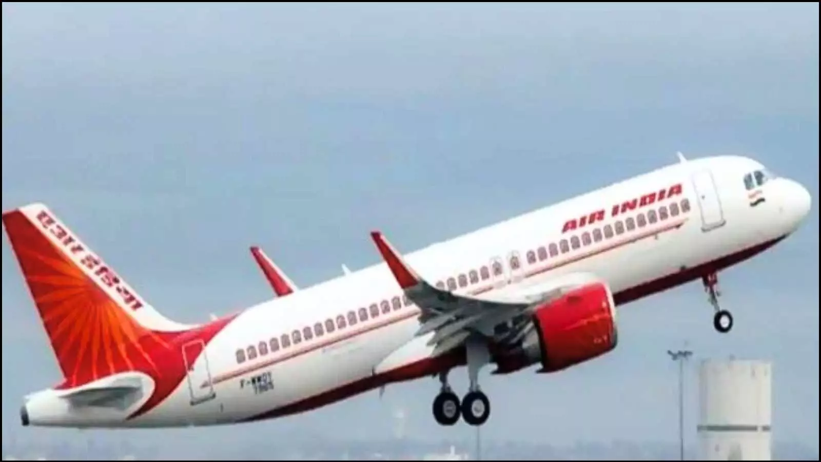 आसमान में उड़ान भरता हुआ एयर इंडिया का सफेद और लाल रंग का यात्री विमान।