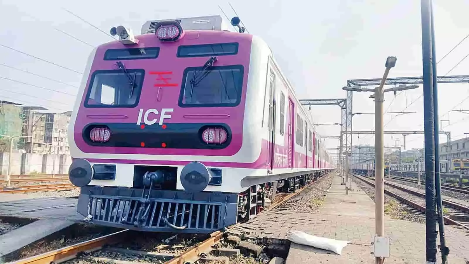 मुंबई के रेलवे स्टेशन पर खड़ी पश्चिम रेलवे की गुलाबी रंग की विशेष लोकल ट्रेन का दृश्य।