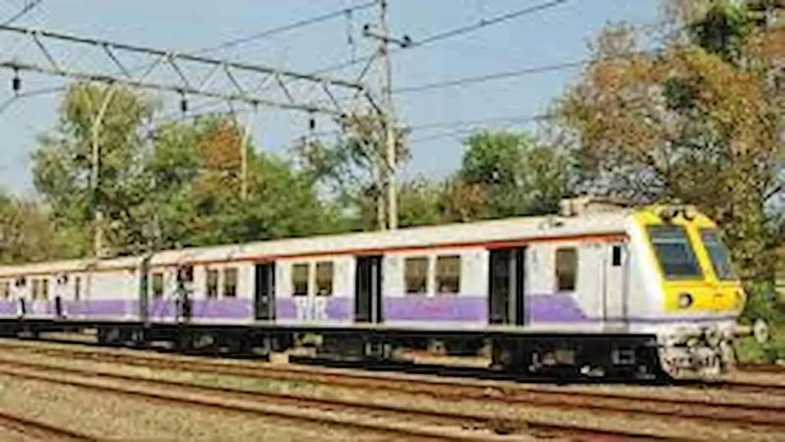 पटरियों पर चलती हुई पश्चिम रेलवे की एक लोकल मेमू ट्रेन का दृश्य।
