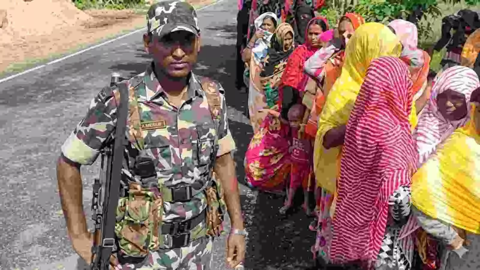 पश्चिम बंगाल के नदिया में चुनाव के दौरान सुरक्षा बल और राजनीतिक दलों के प्रतिनिधि मतदान केंद्र के बाहर।