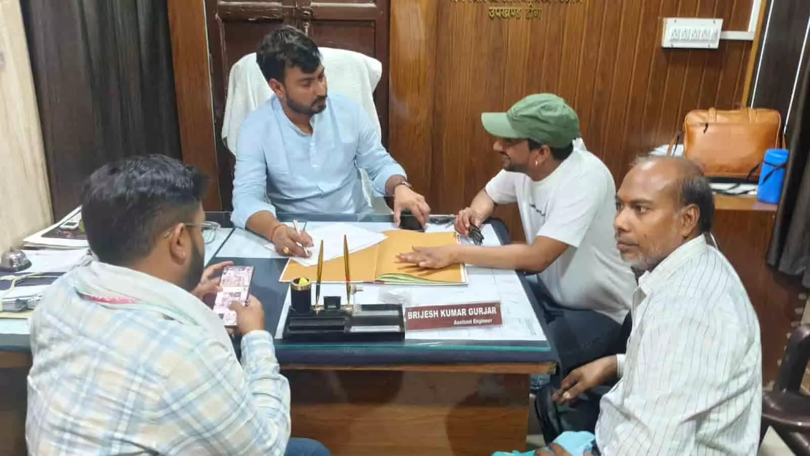 डीग में सहायक अभियंता विजेश गुर्जर के कार्यालय में दूषित पेयजल समस्या पर चर्चा करते ग्रामीण।