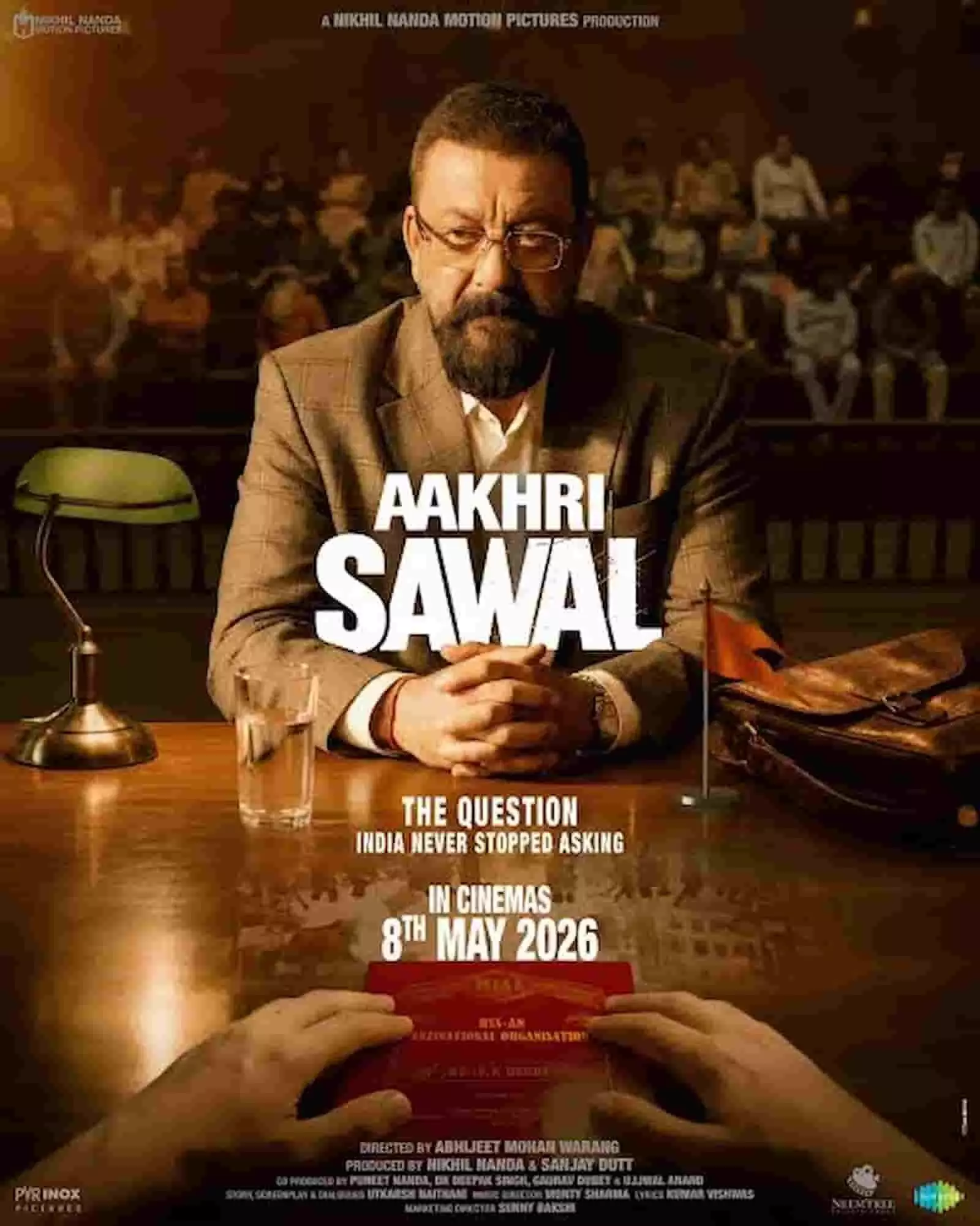 आखरी सवाल फिल्म के पोस्टर में अभिनेता संजय दत्त एक मेज पर हाथ रखे चश्मा पहने दिखाई दे रहे हैं। आखरी सवाल फिल्म के पोस्टर में अभिनेता संजय दत्त एक मेज पर हाथ रखे चश्मा पहने दिखाई दे रहे हैं।