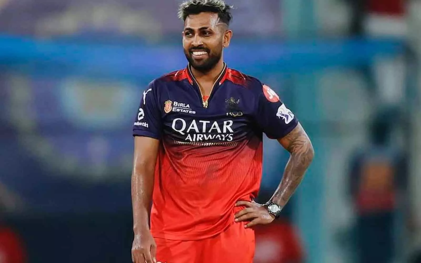 क्रिकेट की जर्सी पहने और मुस्कुराते हुए श्रीलंका के तेज़ गेंदबाज़ नुवान थुशारा मैदान पर खड़े हैं।