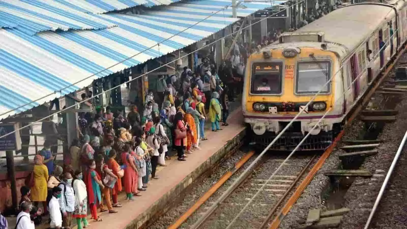 रेलवे स्टेशन के प्लेटफॉर्म पर ट्रेन के आने का इंतज़ार करते यात्रियों की भीड़।