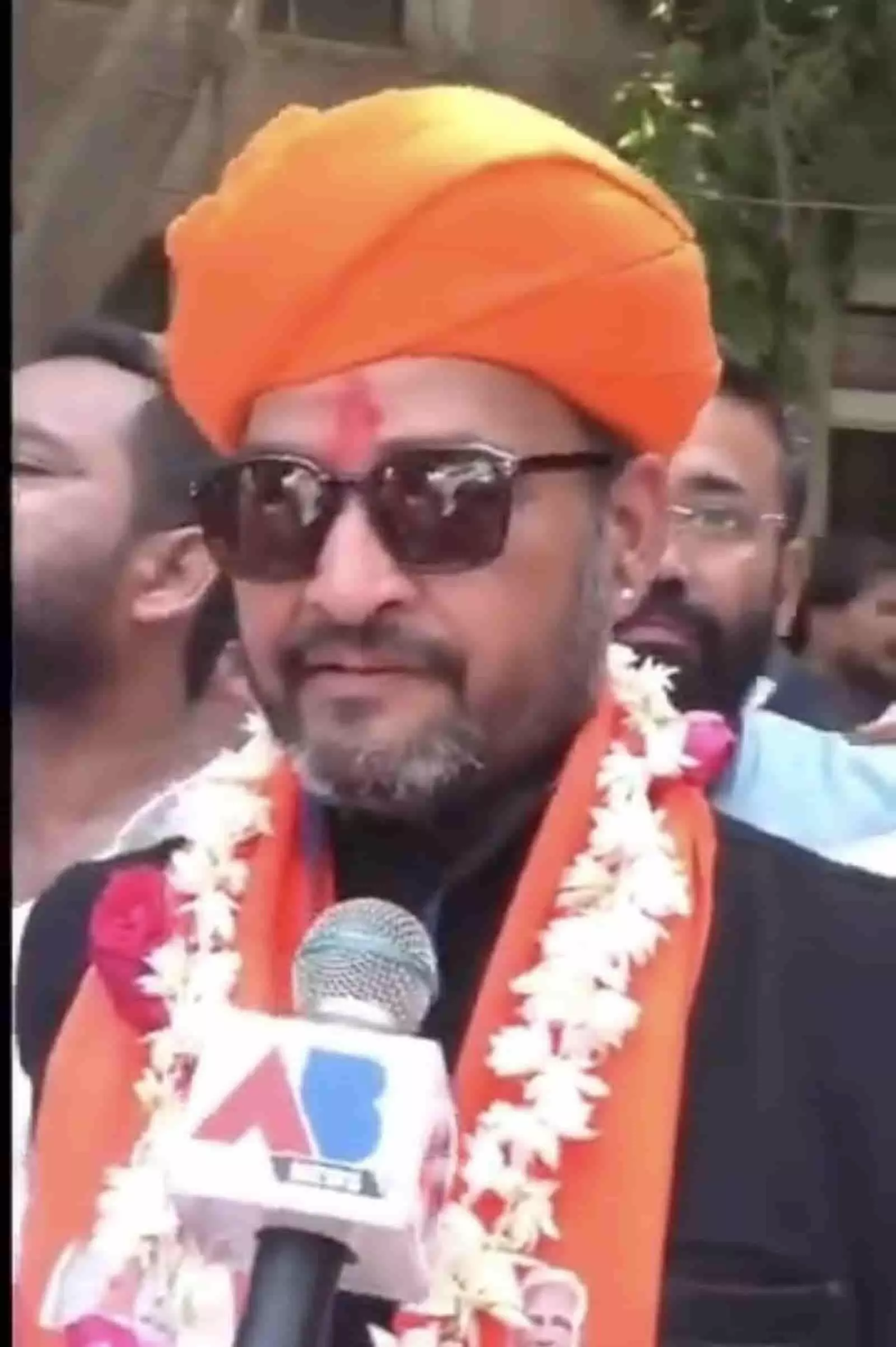नारंगी साफा और चश्मा पहने देवेंद्र कुमार बोकाड़िया सूरत में मीडिया के सामने जीत के बाद उपस्थित। नारंगी साफा और चश्मा पहने देवेंद्र कुमार बोकाड़िया सूरत में मीडिया के सामने जीत के बाद उपस्थित।