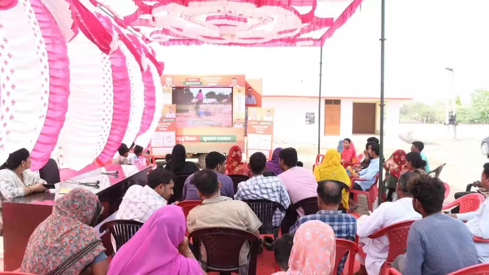 सवाई माधोपुर में एलईडी वैन पर वीडियो देखते ग्रामीण और सजे हुए शामियाने का दृश्य। सवाई माधोपुर में एलईडी वैन पर वीडियो देखते ग्रामीण और सजे हुए शामियाने का दृश्य।