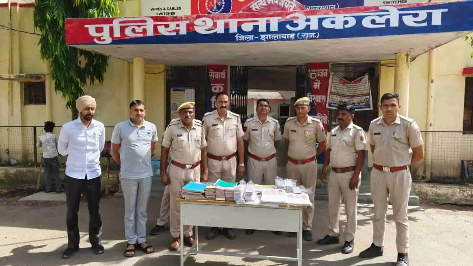 अकलेरा पुलिस थाने के बाहर पुलिस कर्मियों के साथ खड़ा सूदखोरी मामले का मुख्य आरोपी सुगनचन्द मीणा।