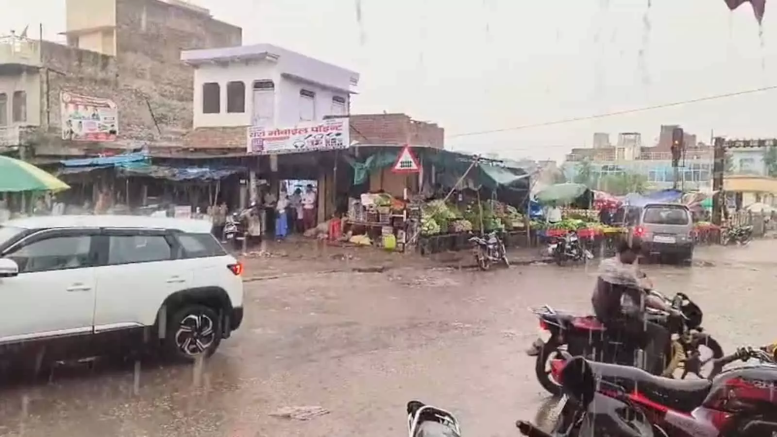 बयाना के बाजार क्षेत्र में बारिश के दौरान सड़कों पर आवाजाही करते वाहन और जलभराव का दृश्य। बयाना के बाजार क्षेत्र में बारिश के दौरान सड़कों पर आवाजाही करते वाहन और जलभराव का दृश्य।