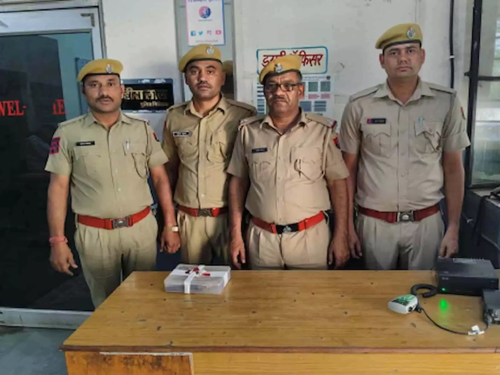 बारां सदर थाने में खड़े चार पुलिसकर्मी मेज पर बरामद हथियार के साथ आरोपी की गिरफ्तारी दर्शाते हुए। बारां सदर थाने में खड़े चार पुलिसकर्मी मेज पर बरामद हथियार के साथ आरोपी की गिरफ्तारी दर्शाते हुए।