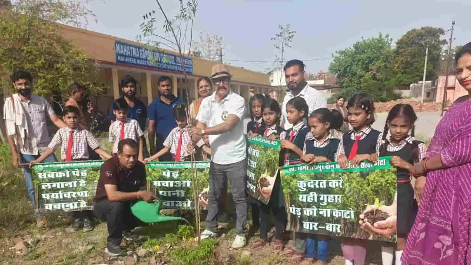 स्कूल परिसर में नीम का पौधा लगाते हुए समाजसेवी दंपति और पर्यावरण जागरूकता बैनर थामे बच्चे। स्कूल परिसर में नीम का पौधा लगाते हुए समाजसेवी दंपति और पर्यावरण जागरूकता बैनर थामे बच्चे।