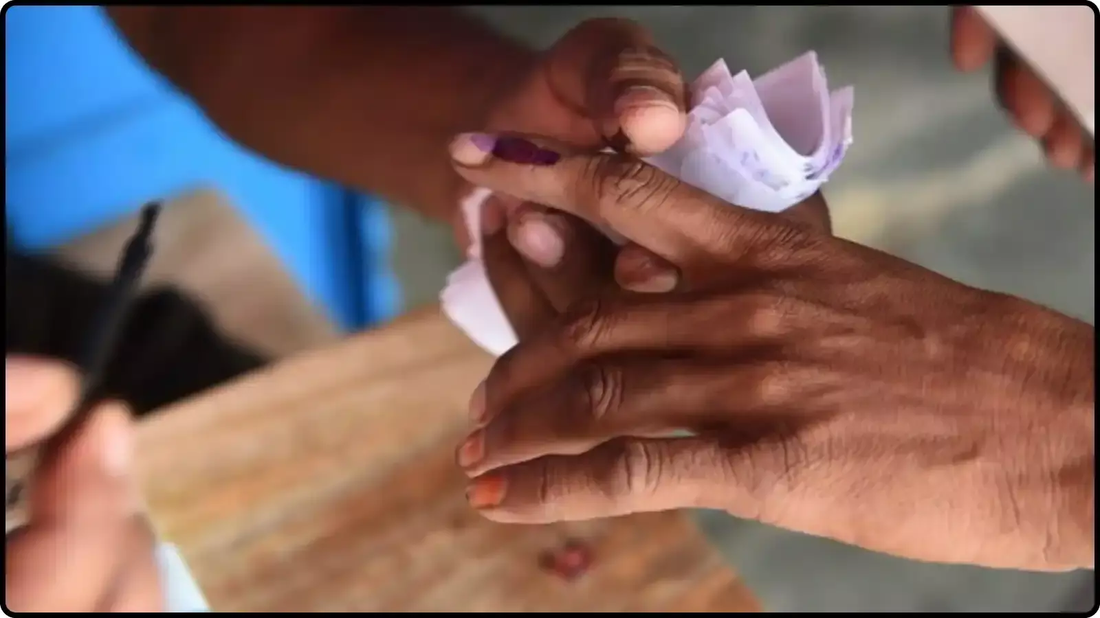 मतदाता की उंगली पर स्याही लगाते चुनाव कर्मी नए क्यूआर कोड सिस्टम और चुनावी प्रक्रिया के संदर्भ में दिख रहे हैं।