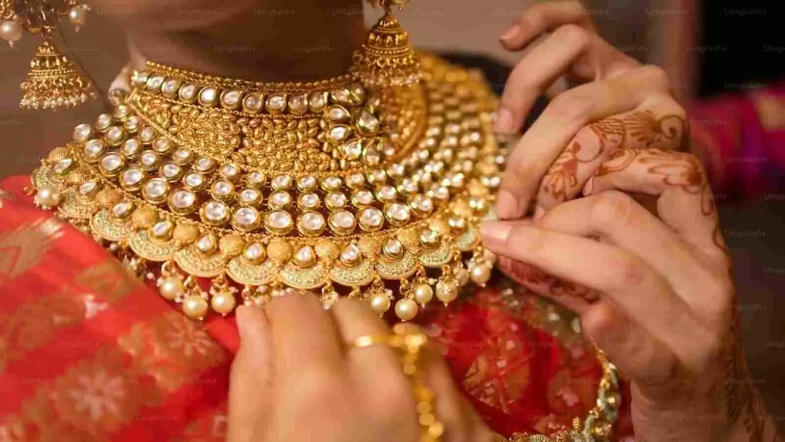 सोने के आभूषण पहने हुए एक महिला की तस्वीर जो भारतीय सर्राफा बाजार के संदर्भ में है।