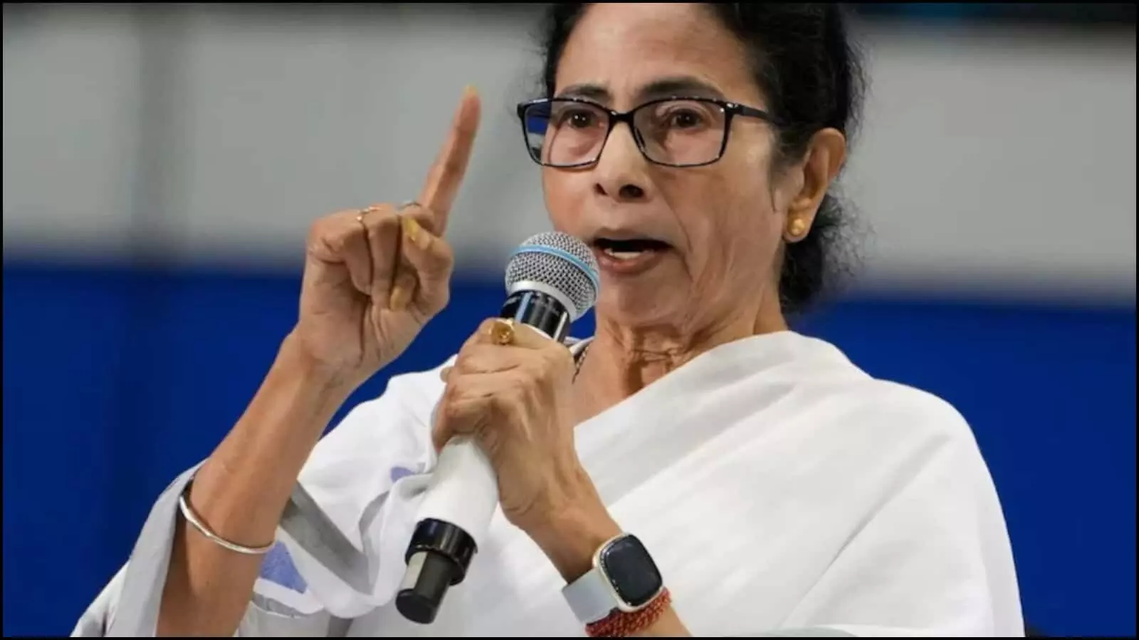 चश्मा पहने और सफेद साड़ी में हाथ उठाकर बोलतीं ममता बनर्जी कोलकाता में चुनाव सुरक्षा पर बयान देते हुए।