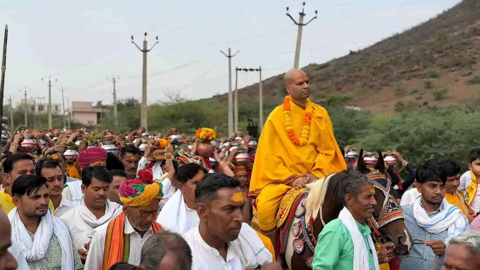 मंडरायल में कलश यात्रा के दौरान घोड़े पर सवार कथावाचक और पैदल चलते श्रद्धालुओं का समूह। मंडरायल में कलश यात्रा के दौरान घोड़े पर सवार कथावाचक और पैदल चलते श्रद्धालुओं का समूह।