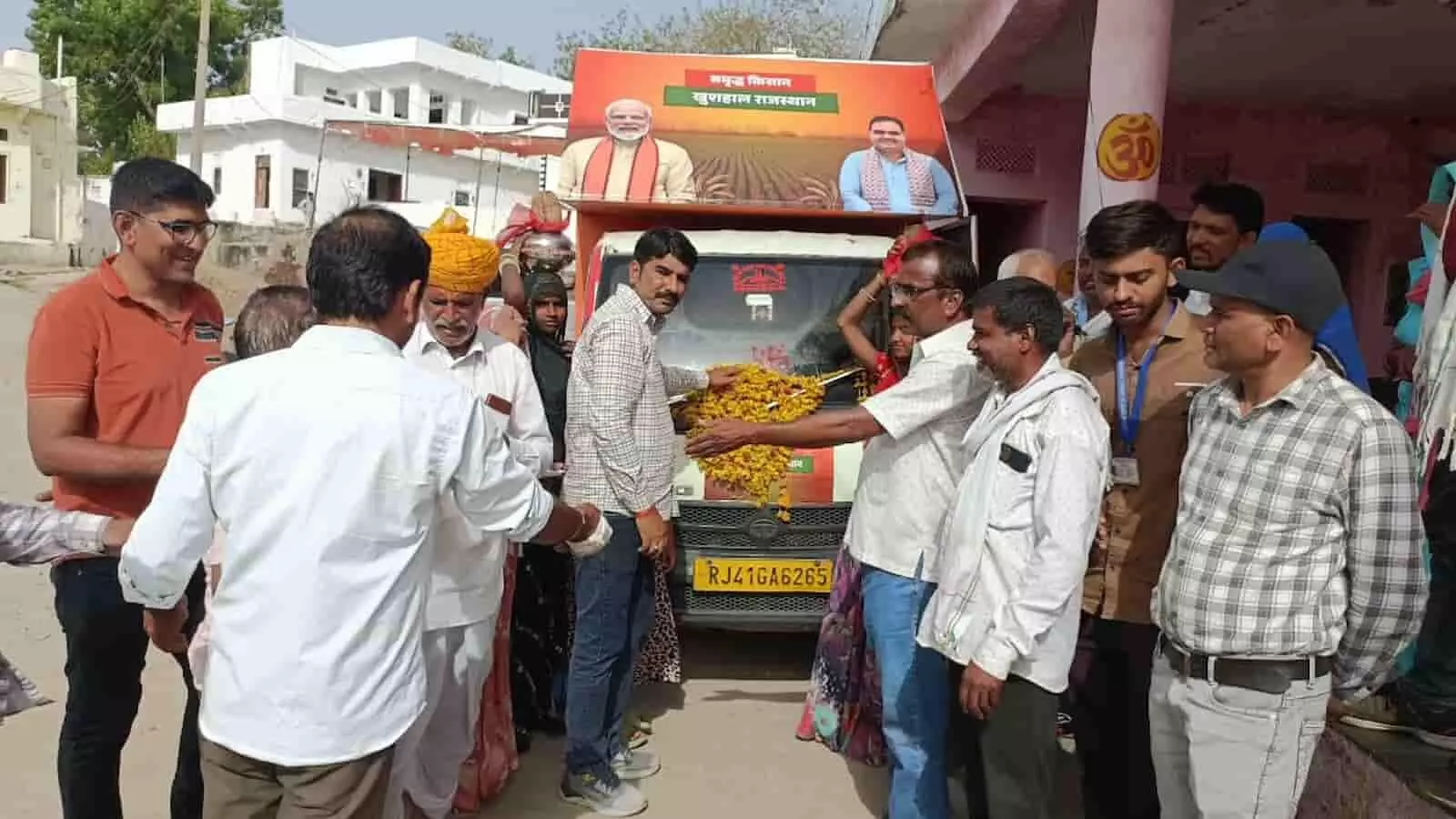 राजस्थान के एक गांव में ग्राम रथ अभियान के प्रचार वाहन के पास खड़े ग्रामीण और अधिकारी। राजस्थान के एक गांव में ग्राम रथ अभियान के प्रचार वाहन के पास खड़े ग्रामीण और अधिकारी।