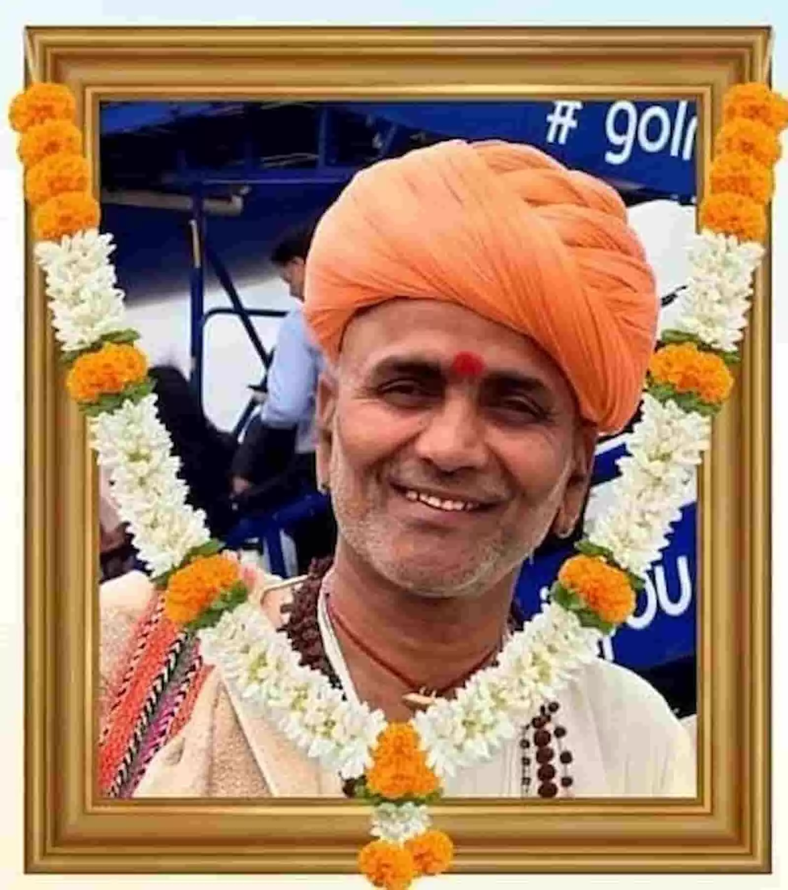 फ्रेम में लगी स्वर्गीय भजन गायक धनराज जोशी की तस्वीर जिन पर फूलों की माला चढ़ी हुई है।