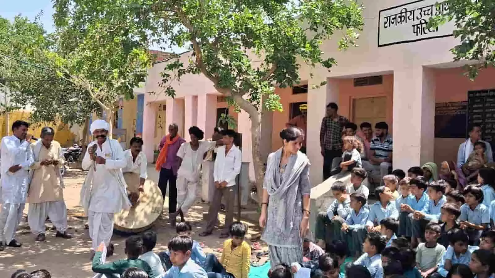 राजकीय विद्यालय के बाहर लोक कलाकार ग्रामीणों और बच्चों को योजनाओं के प्रति जागरूक करते हुए। राजकीय विद्यालय के बाहर लोक कलाकार ग्रामीणों और बच्चों को योजनाओं के प्रति जागरूक करते हुए।