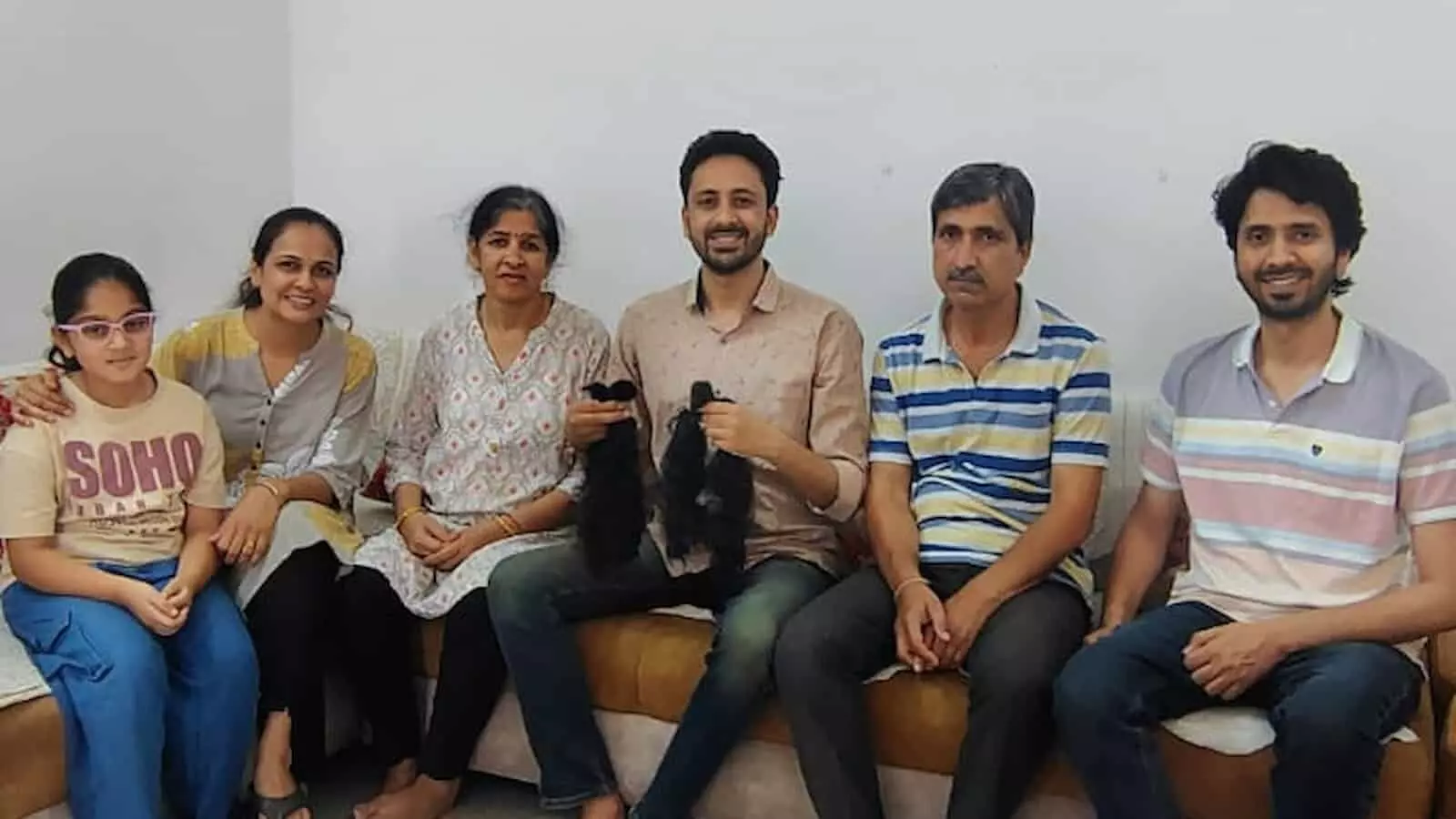 कमरे में सोफे पर बैठे रोनक कंठालिया कटे हुए बाल हाथ में लेकर परिजनों संग उदयपुर में केश दान के उपलक्ष्य में। कमरे में सोफे पर बैठे रोनक कंठालिया कटे हुए बाल हाथ में लेकर परिजनों संग उदयपुर में केश दान के उपलक्ष्य में।