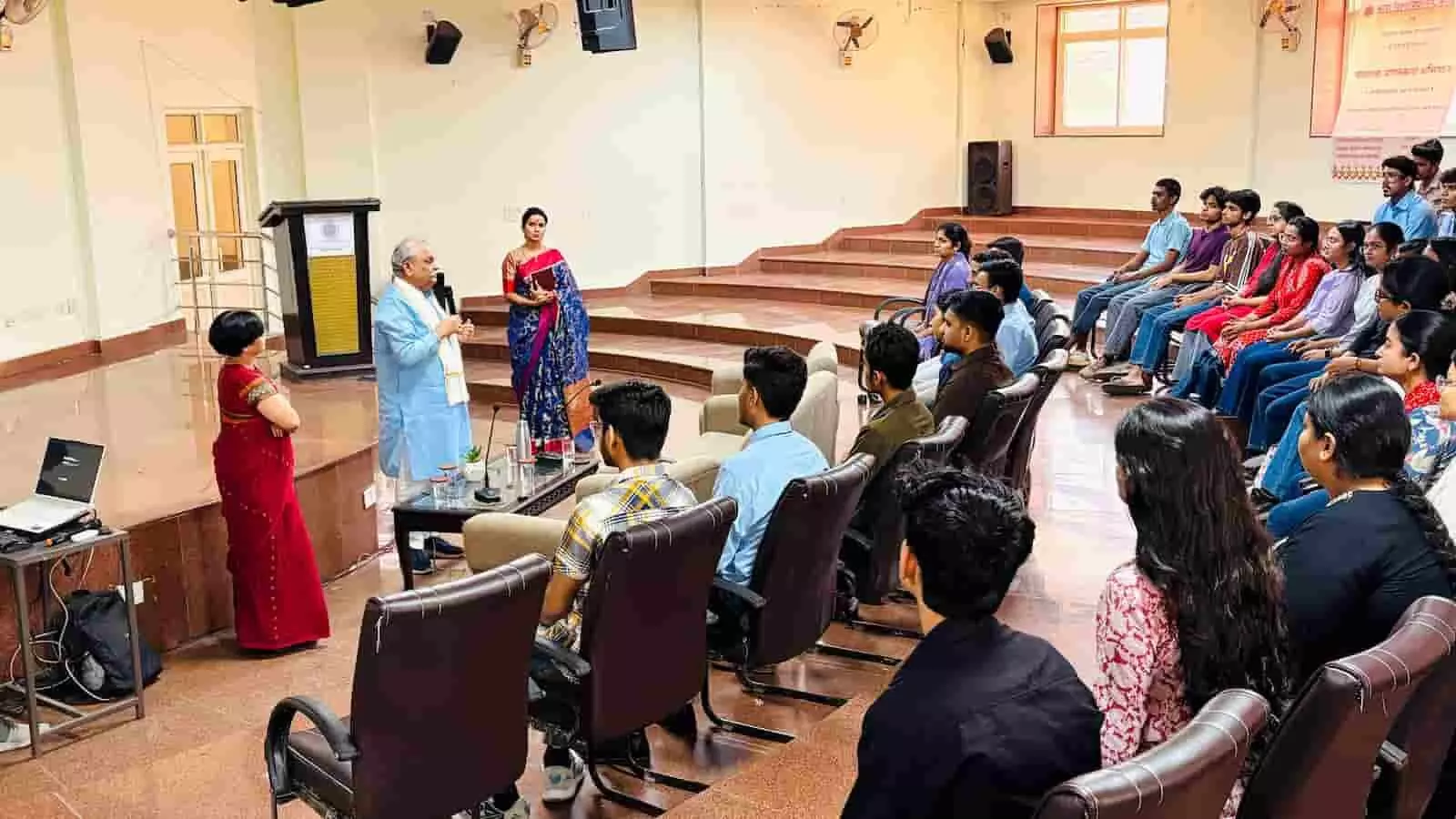 कोटा विश्वविद्यालय के सभागार में कुर्सियों पर बैठे छात्र और मंच के समीप चर्चा करते हुए अतिथि एवं वक्ता। कोटा विश्वविद्यालय के सभागार में कुर्सियों पर बैठे छात्र और मंच के समीप चर्चा करते हुए अतिथि एवं वक्ता।