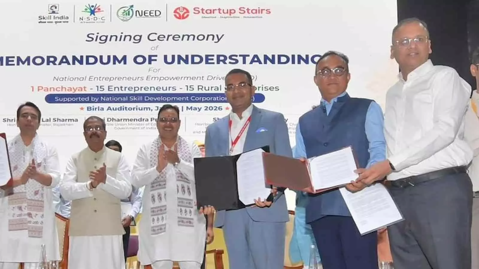 बिड़ला ऑडिटोरियम जयपुर में मंच पर एमओयू दस्तावेज दिखाते हुए अधिकारी और गणमान्य अतिथि।