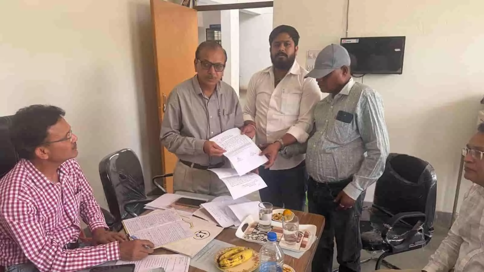 कार्यालय में मेज के पास खड़े व्यक्ति अधिकारियों को विद्या संबल योजना संबंधी शिकायत पत्र सौंप रहे हैं। कार्यालय में मेज के पास खड़े व्यक्ति अधिकारियों को विद्या संबल योजना संबंधी शिकायत पत्र सौंप रहे हैं।